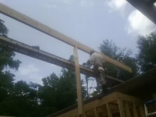 Carpenter setting a ridge beam over a new addition frame — Ice Dam Removal by Roofing Brothers in Fishing Creek