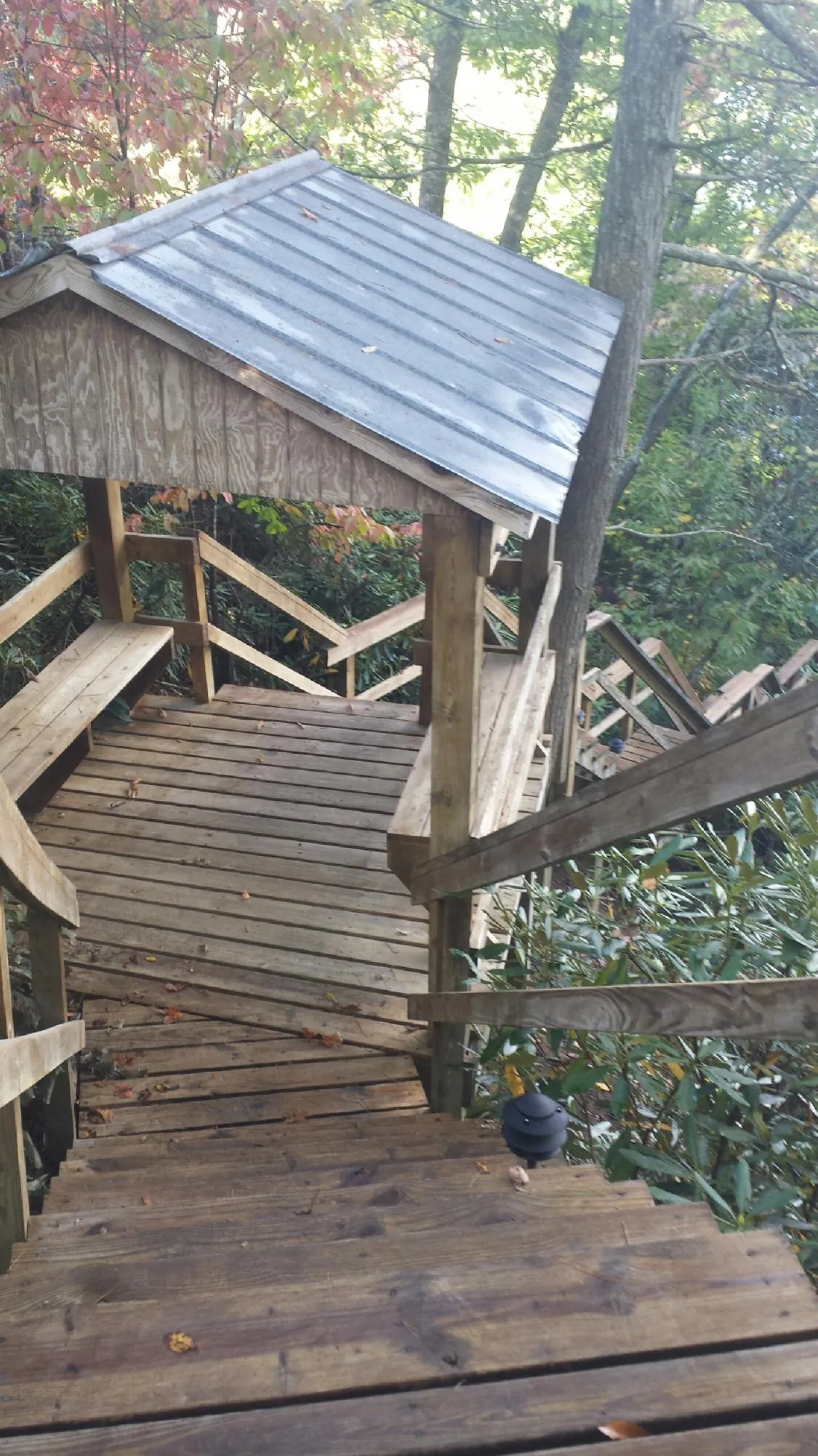 Metal roofed shelter over wooden steps on a wooded walkway — Skylight Repair & Installation work by our crew in Fishing Creek