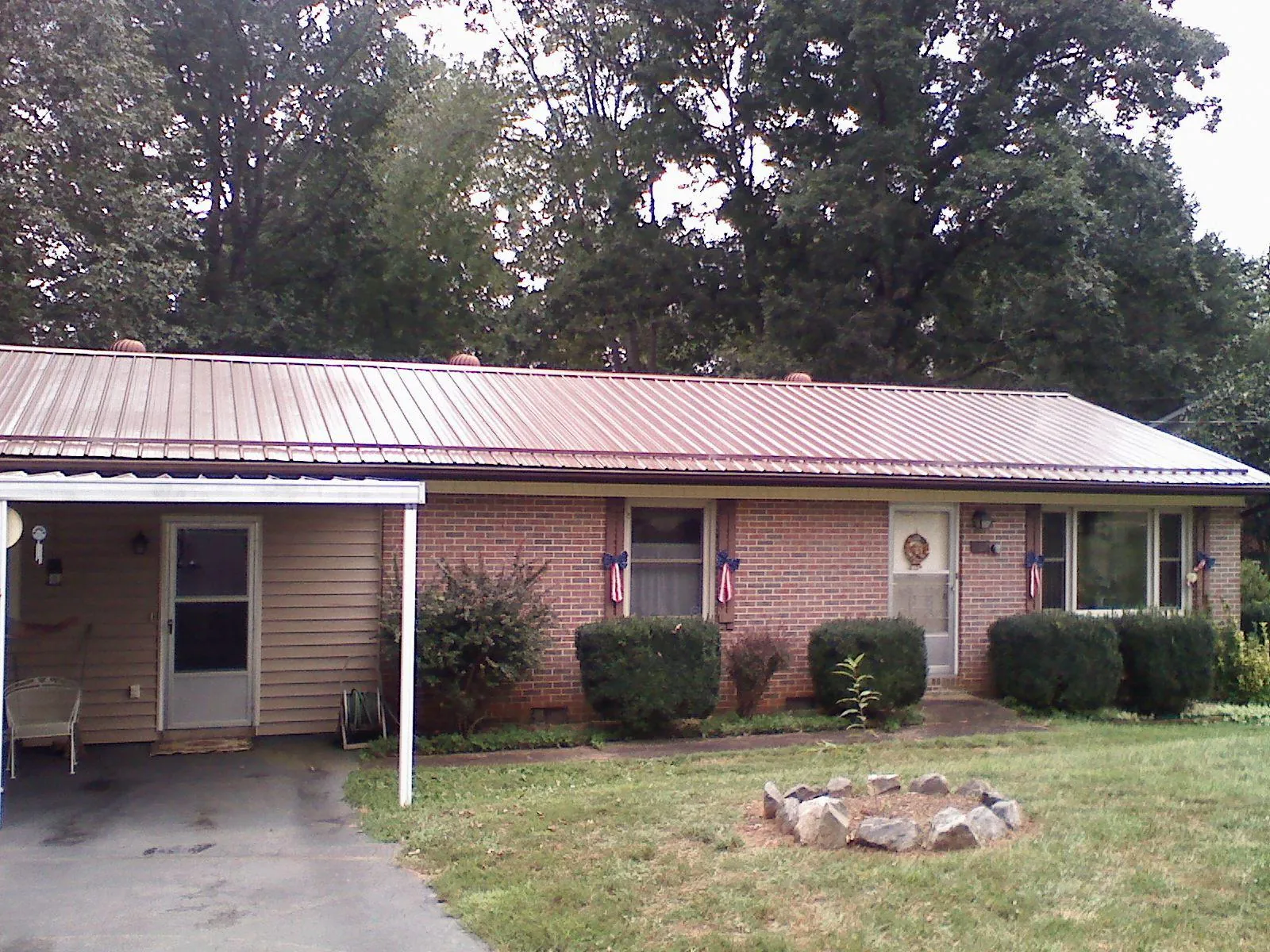 Bronze metal roof and carport on a brick ranch home — Roof Repair work by our crew in Fishing Creek